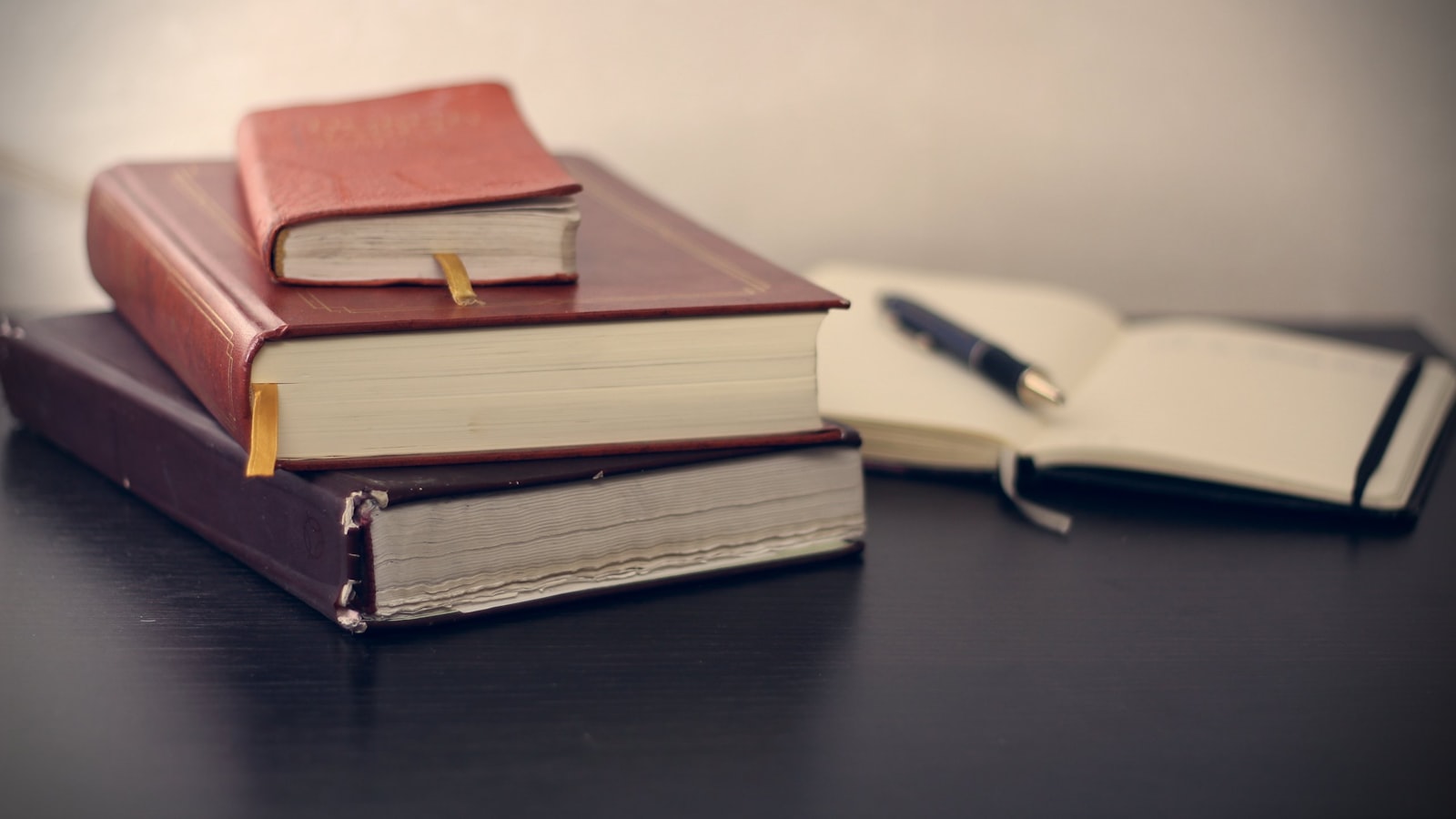 Códigos e livros de legislação empresarial e tributária ao lado de caneta e caderno, base do trabalho consultivo
